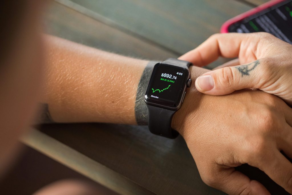 pexels photo 7947957 7947957 Close-up of a smartwatch showing stock market data, with hands wearing it.